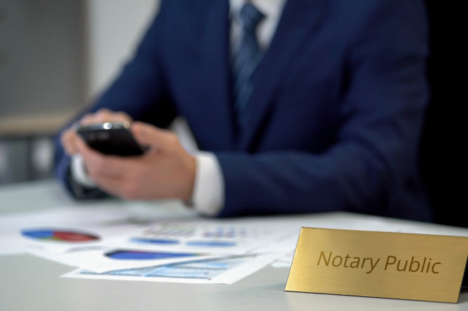 Notary public holding smartphone and working with documents